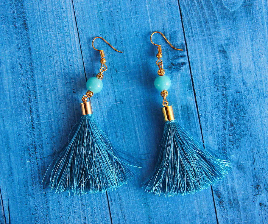 Blue Earrings Placed on Blue Wooden Surface