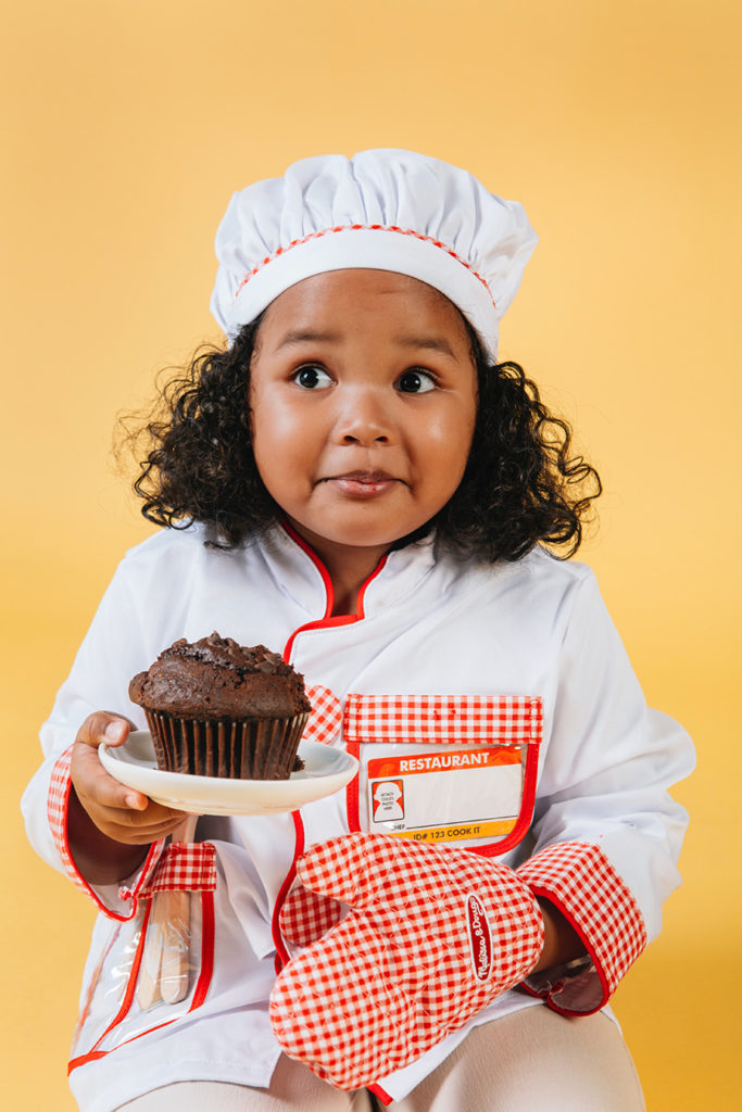 Little Girl Holding Cupcake With An Oven Mitt On One Hand